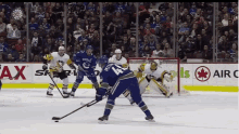 a hockey game is being played in front of an air canada sign