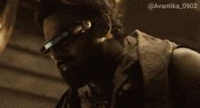 a man with a beard wearing a pair of futuristic glasses with the number 0902 on the bottom