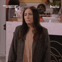 a woman stands in front of a hulu sign