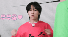a man wearing a red sweater with the letter t on it