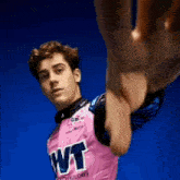 a young man wearing a pink jersey with the word wt on the front