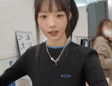 a woman wearing a black shirt and a necklace with a key on it