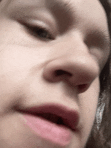 a close up of a woman 's face with a pink lipstick on her lips