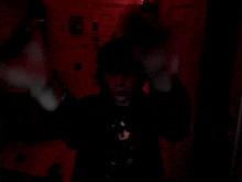 a person in a dark room with a sticker on the wall that says ' hot dog '