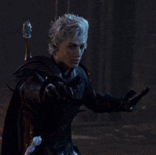 a man with silver hair is holding a sword in a dark room
