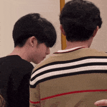 a close up of a man 's back with a striped shirt on