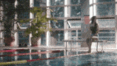 a woman sits on a bench near a swimming pool with a sign that says no diving