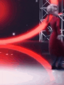 a person in a red dress is dancing on a stage .