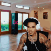a man wearing headphones and a hat has a tattoo that says fire