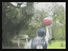 a man wearing a seahawks jersey is holding a basketball over his head