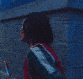 a man in a red shirt with the number 12 on it is standing in a hallway