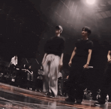 a man in a black shirt is standing on a stage with other people