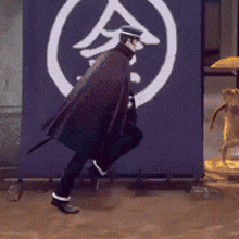 a man in a cape is walking in front of a sign that has chinese characters on it