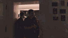 a group of men are hugging in a dark room