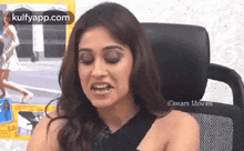 a woman is sitting in a chair with her eyes closed and her mouth open .