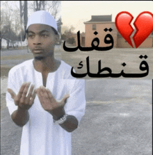 a man praying in front of a broken heart with arabic writing