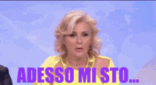 a woman in a yellow dress says adesso mi sto on a blue background