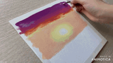 a person is painting a sunset on a canvas with the words made in animotica on the bottom