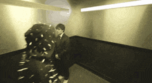 a man in a suit and tie stands in a hallway with confetti falling around him