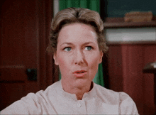 a woman in a pink shirt with a button on the front
