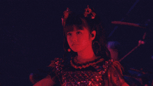 a girl with pigtails is wearing a red dress