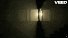 a dark room with a light coming out of a door and the word veed above it