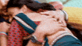 a man is touching a woman 's back while they are laying on a bed .