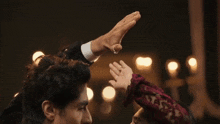 a man is holding a woman 's hand over her eyes .