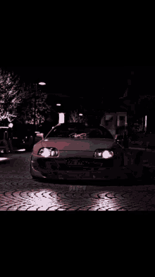 a pink sports car is driving down a road
