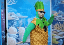 a man in a pineapple costume is pointing to something