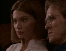 a man and a woman are looking at each other in a dark room