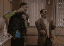 a couple of men are standing next to each other in a room .