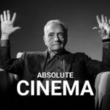 a man in a suit is sitting in a chair with his hands in the air and the words absolute cinema below him