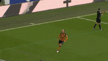 a soccer player wearing a black and orange jersey with the number 6 on it