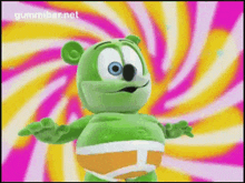 a gummy bear is standing in front of a pink and yellow swirl background