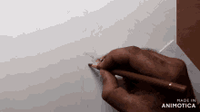a person is drawing on a piece of paper with the words made in animotica on the bottom right