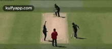 a cricket game is being played on a field with a gillette ad in the background .