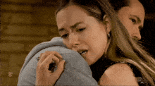 a woman is hugging a man with a cbs logo on the bottom right