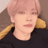 a close up of a person 's face with pink hair and a black shirt .