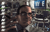 a man is smoking a cigar in front of a nyse billboard