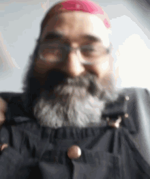 a man with a beard and glasses is wearing overalls and a red hat