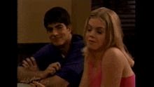 a man and a woman are sitting at a table .