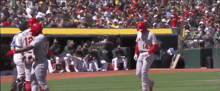 a baseball player with the number 12 on his jersey is hugging another player on the field .