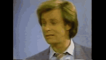 a man in a suit and tie is making a face