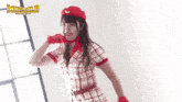 a woman wearing a red hat and red gloves is standing in front of a sign that says mammut
