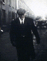 a man in a suit and tie is walking down a street