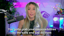 a woman in front of a microphone with the words you gotta grab your responsibilities by the balls and just do them below her