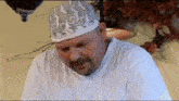 a man wearing a white shirt and a white hat with a dragon design