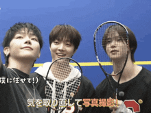 a group of young men holding tennis rackets with the number 3 on their sweatshirt