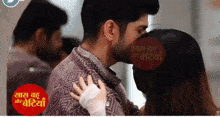 a man kisses a woman on the forehead in front of a sign that says " saas bahu and bediyan "